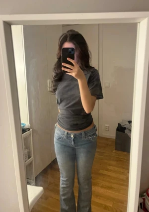 Lågmidjade bootcut jeans i ljusblå denim - Säljer ett par snygga lågmidjade jeans i ljusblå denim med bootcut-ben. Klassisk femficksmodell och cool tvätt som ger en avslappnad vibe. Perfekta för dig som gillar retrostil och vill ha ett par jeans som sticker ut.