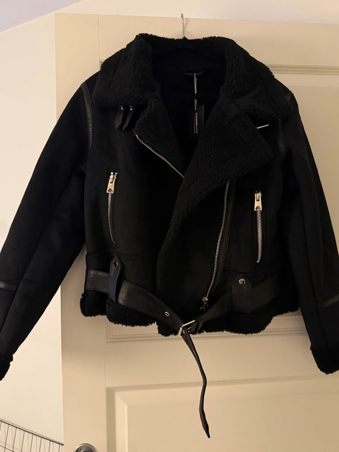 Svart teddyjacka med bälte och dragkedjor