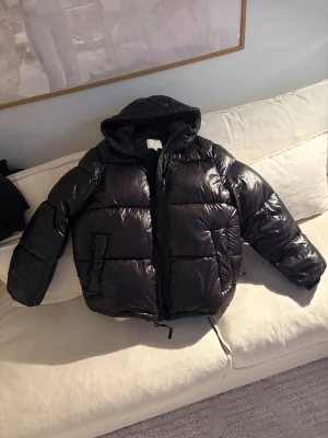 Svart pufferjacka - En svart, glansig pufferjacka med luva 🧥🤍