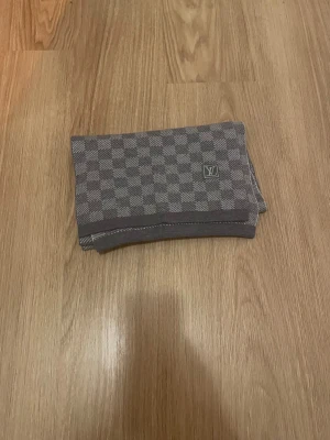 Rutig grå halsduk  - Bekväm och varm halsduk med ett grått rutmönster. Värmer halsen väldigt bra och är perfekt för att ge dig en stilren och snygg look. Kontakta för fler bilder eller om ni har några frågor!