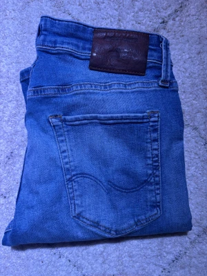 Jack&Jones jeans - Säljer dessa fina jeansen från Jack & Jones i blått för bara 249. Byxorna har en snygg, unik färg och är modellen Slim/glenn vilket sitter slim. Dem är i väldigt fint skick och finns inte mycket tecken på användning.  Dem är redo att hitta ett nytt hem! Fråga gärna om ni vill ha fler bilder eller mer information