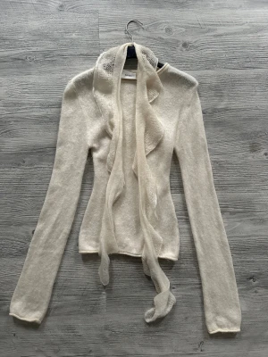 Vit stickad tröja från Arakii - Superskön off white, stickad tröja från Arakii. Finns inte längre tillgänglig på deras webbshop. Tröjan har en tillhörande scarf och har långa ärmar. Den är i gott skick och kan skickas direkt :) 