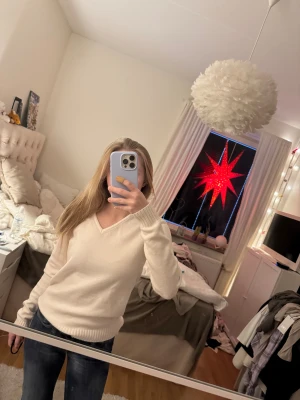 Vit V-ringad stickad tröja - V-ringad vit stickad tröja som inte kommer till användning! Den har två små svarta fläckar på baksidan (se bild 4) och är lite nopprig men inget som direkt märks av!