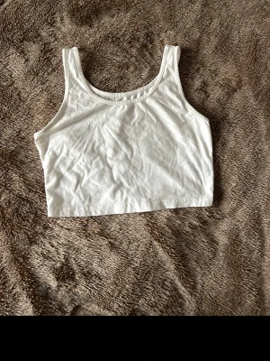 Topp - Säljer en enkel och stilren vit croppad linnetopp. 