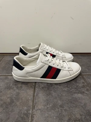 Gucci Ace skor - Feta Gucci Ace skor. Storlek 8 1/2 US motsvarar 42,5. De är repainted på sidan av sulan (se bild 5) annars väldigt bra skick. Kvitto och dustbag medkommer. Pris kan självklart diskuteras!!