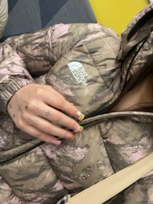 Camo pink pufferjacket from The North Face - Säljer en pufferjacka från The North Face med camomönster l jusrosa. Den är väldigt varm och perfekt för Sveriges vinter ! Köpte den för en månad sen, så den är i nytt skick, men köpte en strl för litet. Därför säljer jag den nu🖤