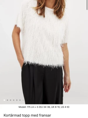 NA-KD topp med fransar och glitter - Säljer min topp från NA-KD i mycket bra skick men den har använts några gånger. Säljer pga att den inte passar mig. Superfin kort vit topp, med fransar och glitter samt en öppen rygg med snörning!🎀 Nypris 259,50 kr