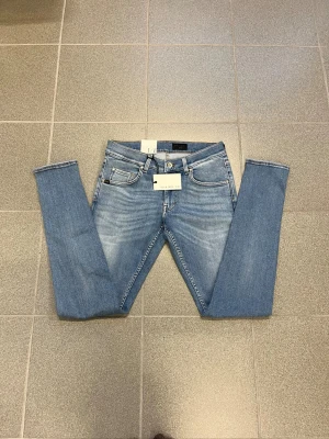 Ljusblå slimmade jeans från Tiger of sweden W30 L32 - Snygga ljusblå jeans från T/J med slimmad passform och smala ben. Klassisk femficksmodell med läderpatch bak i midjan. Jeansen har en fräsch tvätt och är perfekta för dig som gillar en slim och modern look.