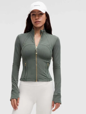 Grön zip-jacka från Lululemon - Supersnygg  defined cropped jacket från Lululemon med dragkedja framtill och hög krage i färgen forest green med guldig dragkedja. Jackan har figurnära passform, långa ärmar med tumhål och diskreta sömdetaljer. Perfekt för träning eller en aktiv vardag. Utan defekter eller tecken på användning, vid snabbaffär är priset något diskuterbar.