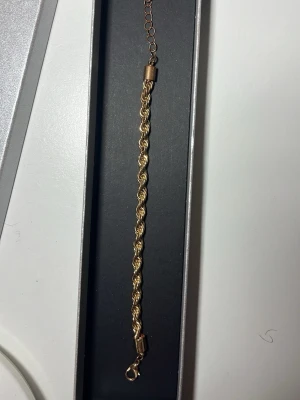 Guld färgat cordell armband - Ett guld färgat cordell armband som knappast är använt. Den har tappat lite färg bara där jag visar på bild 3. 15cm. Går ej att duscha med den kan rostas men den håller länge hade en annan. Pris kan diskuteras.