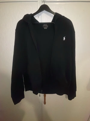 Polo Ralph lauren zip  - Svart zip hoodie från Polo Ralph Lauren  Storlek S  Klassisk modell med broderad logga på bröstet. I fint skick, inga större tecken på slitage. Perfekt basic – funkar till allt.
