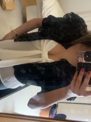 Svart croppad kofta med volang från Zara - Supersöt svart kofta från Zara med stickade detaljer och volanger över axlarna. Koftan har knappar framtill och är croppad den är från en gammal kollektion från Zara finns ej att köpa eller hitta. Är i väldigt bra skick 