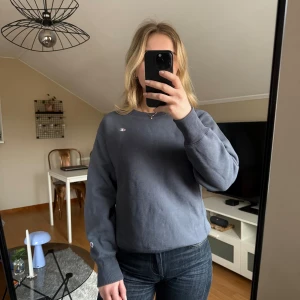 Champion sweatshirt S - Stålblå grå sweatshirt från Champion i Reverse Weave-modell. Klassisk crewneck med liten broderad Champion-logga på bröstet och ärmen. Tröjan är i mjuk bomullsmix och har ribbade muddar vid ärmslut och midja. Perfekt för chill dagar eller när du vill ha en clean streetstyle. Storlek S