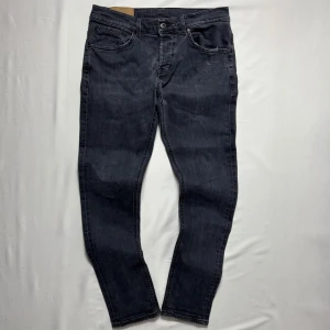 Dondup George - Mörkgrå jeans från Dondup med klassisk femficksdesign och schyssta detaljer.                                                  Modell: George.                                                                      Storlek: 34.                                                                            Skick: 9/10.                                                                         Tveka inte att höra av dig vid minsta fundering!