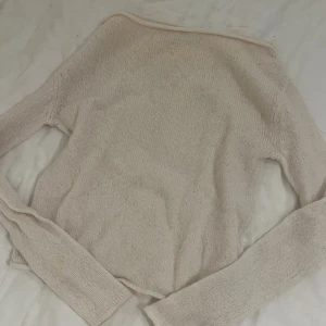 Vit stickad långärmad tröja - En enkel och mjuk stickad tröja i vit ton. Tröjan har lång ärm och rund hals, perfekt för dig som gillar en clean och chill stil. Passar dig som vill ha något neutralt och lätt att matcha med andra plagg.