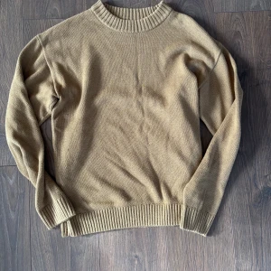 Beige stickad tröja från Jack & Jones - Säljer en beige stickad tröja från Jack & Jones i storlek M. Tröjan har rund halsringning och ribbade muddar vid ärmslut och nederkant. Perfekt för lager-på-lager och enkel att matcha med jeans eller chinos. Hör av dig vid frågor!!!