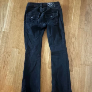 Svarta BECCA true religion bootcut jeans - Svarta becca true religion jeans. Utsvängda. I storlek 24