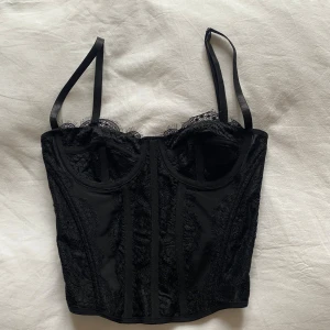 Korsett topp i spets - Säljer denna fina korsett topp med spets på pågrund av att den är lite för liten för mig. Vanliga spänne i ryggen där man kan välja om den ska vara lite mindre eller lite större. Spännbara axelband. Storlek XS