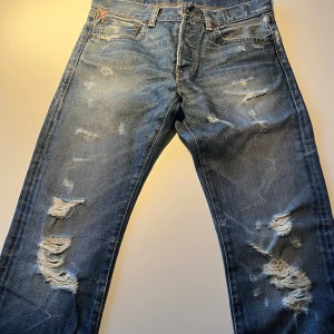 Ripped jeans från Ralph Lauren Denim & Supply - Snygga blå jeans från Ralph Lauren Denim & Supply med slitna och rivna detaljer på både fram- och baksida. Klassisk femficksmodell med normal passform och rak siluett. Tillverkade i 100% bomull för en autentisk denimkänsla.