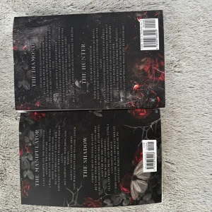 Haunting Adeline / Hunting Adeline - Två böcker med mörka, mystiska omslag prydda av rosor, fjärilar och dödskallar. Perfekt för dig som gillar spänning, skräck och romantik med en gotisk twist. Passar unga vuxna som söker intensiva berättelser och nervkittlande läsning. Köpta från bokaffären, bra skick, 590kr var. Säljer därför för 1000kr.