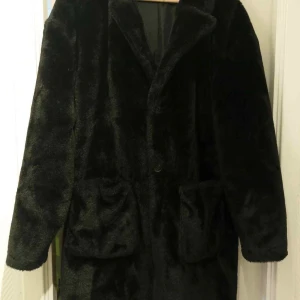 Svart pälsjacka från Another Influence storlek L - Säljer en svart pälsjacka från Another Influence i storlek L. Jackan har två stora fickor framtill, klassisk krage och är helsvart med mjuk pälsig yta. Perfekt för dig som vill ha en cool och varm look under höst och vinter. Jackan är i mycket fint begagnat skick