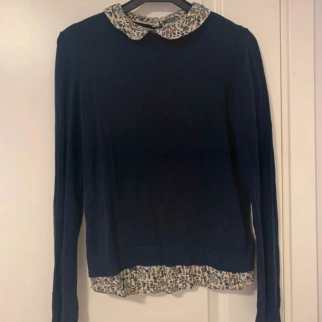 Mörkblå tröja med blommig krage