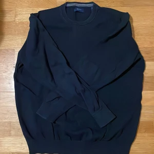 Mörkblå stickad tröja från GANT - Snygg mörkblå stickad tröja från GANT är xl men skulle säga att det passar l för den ör lite slimfit 