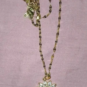 Solros halsband med glittrig hängsmycke i rostfritt stål med 18k guldpläterad  - Unikt halsband med solrosformat hängsmycke i rostfritt stål med 18k guldpläterad och glittriga stenar som kronblad. Kedjan är guldfärgad med ett snyggt mönster och smycket har en detaljrik mitt. Perfekt för dig som vill sticka ut med något extra.