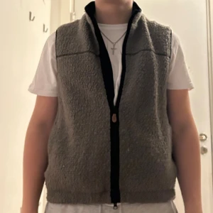 fleeceväst från morris  - Mysig grå fleeceväst från Morris med svart kant och dragkedja framtill. Västen har en enkel design med hög krage och mjukt, fluffigt material som håller dig varm.