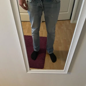 Ljus Blåa Nudie Jeans Grim Tim  - Tjena! Säljer nu mina ljus blåa Nudie Jeans i modellen Grim Tim med en liten slitning på låret! Storlek W29 L32 men sitter mer som W30/31 L32!9/10 skick vid intresse så tveka inte på att höra av er! Priset ej hugget i sten! 