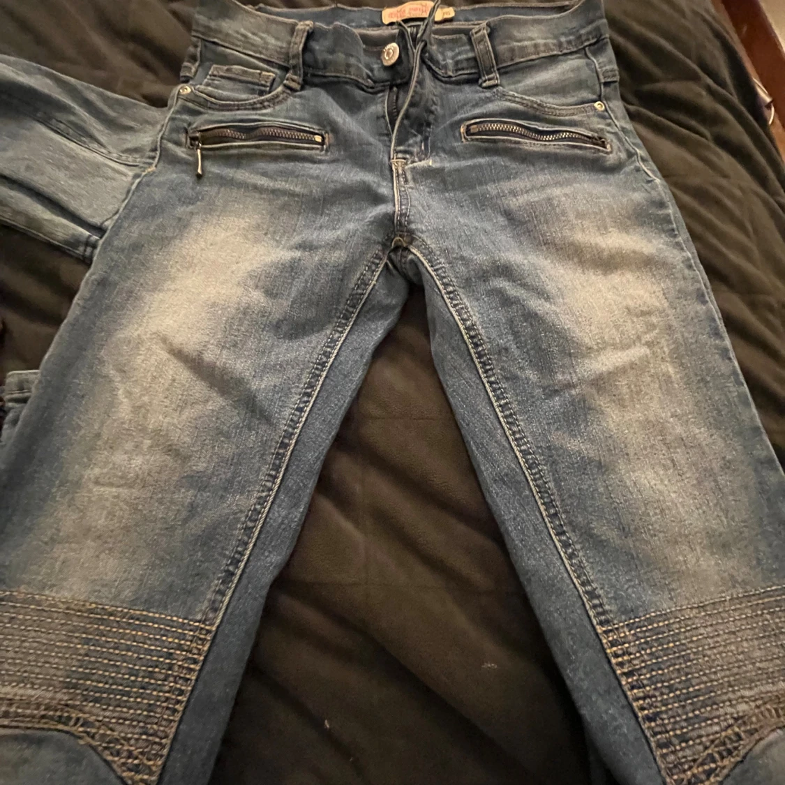 Blåa jeansbyxor med dragkedjedetaljer - 1