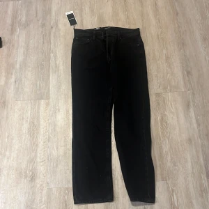 Svarta relaxed jeans från Jack & Jones -  Säljer helt nya Svarta jeans från Jack & Jones i modellen Chris med relaxed fit, hög midja och raka ben. Tillverkade i svart denim med klassiska fem fickor och bälteshällor. Perfekta för dig som gillar en avslappnad och stilren look.