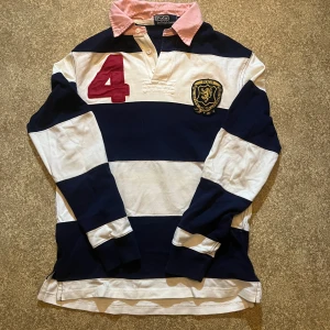 Randig pikétröja Ralph Lauren  - Klassisk långärmad pikétröja från Polo Ralph Lauren i marinblått och vitt i 100%Bomull. Storlek S 