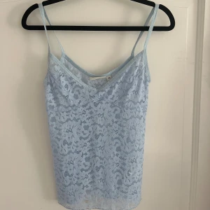 Ljusblå spetslinne - Ljusblått linne i spets från Kappahl i storlek XS. Toppen har tunna axelband och är helt täckt av ett  spetsmönster med blommiga detaljer. 
