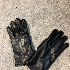 *EJ ANVÄNDA* Skinnhandskar fr. Ellegant - Tja, säljer ett par Svarta Skinnhandskar från Ellegant i modellen DETROIT. De har en Kashmir/merinoull insida vilket gör de väldigt varma och mjuka inuti. Utanpå är det läder som ger det en elegant och stilren look. DE ÄR HELT OANVÄNDA, de sitter fortfarande ihop med plast grejen. Hör av er vid frågor!😁