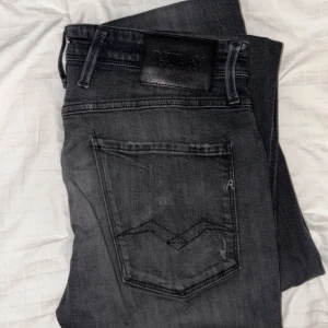 Replay Anbass Jeans - Replay Anbass Jeans, svart/grå. Med slitningar. Storlek 31. Jättefint skick. Köpta för cirka ett år sedan.