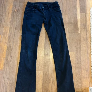 Lågmidjade bootcut ltb jeans  - Säljer dess väldigt mörkblå, näst in till svarta jeansen från Itb. De är i modellen low waist bootcut och är i storlek W26 L32. De är i bra skick men lite slitna längst ner som ni kan se på bild 6. Sedan var de förstora så jag tog in ett band för att kunna justera midjan men de är bara att dra ut om man inte vill ha de (de kommer inte synas).