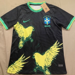 Svart Brasil fotbollströja Nike - Svart Brasilien fotbollströja från Nike med gula fåglar. Tröjan är storlek S, män. Den är helt ny och aldrig använd. Skickar inom 1-3 dagar