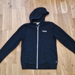 BOSS Zip Hoodie – Svart -  Säljes i fint skick Klassisk svart zip hoodie från Boss Storlek M, bekväm passform Frakt samma dag vid köp 💸 Pris kan sänkas vid snabb affär Vid frågor eller intresse – skriv gärna