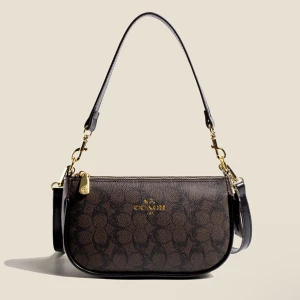 Coach axelväska med monogrammönster - Snygg axelväska från Coach med klassiskt monogrammönster och guldfärgade detaljer. Finns i mörkbrun, beige och vit, alla med rundad form och justerbar axelrem. Väskan är tillverkad i skinn och har dragkedja upptill samt logotyp framtill.