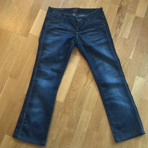Blå bootcut jeans från Bik Bok - Snygga blå jeans från Bik Bok med bootcut-modell och klassisk femficksdesign. Jeansen har ljusa slitningar framtill, kontrastsömmar och broderad detalj på bakfickan. Jeansen är väldigt lågmidjade. Jag köpte dem på Plick men har inte använt dem pågrund av att de är lite korta på mig 169 cm. 