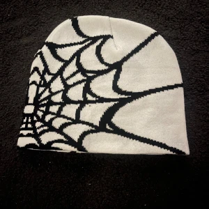 3st Stickad mössa med spindelnätsmönster -   .Cool stickad mössa med spindelnätsmönster för alla kön. Finns i svart grå, vit svart och svart vit. Perfekt nu när det börjar bli kallt 