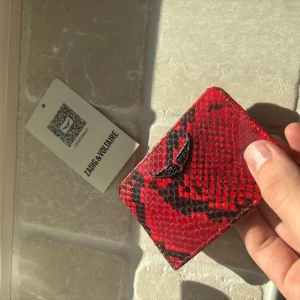 Zadig Voltaire plånbok/korthållare - Zadig Voltaire korthållare/plånbok i väldigt sällsynt colorway. Denna är du ensam om att ha samtidigt som den lyfter din look och förvarar dina kärare ägodelar. Tag kvar! Helt ny så riktigt kap och tveka inte vid minsta fråga😊