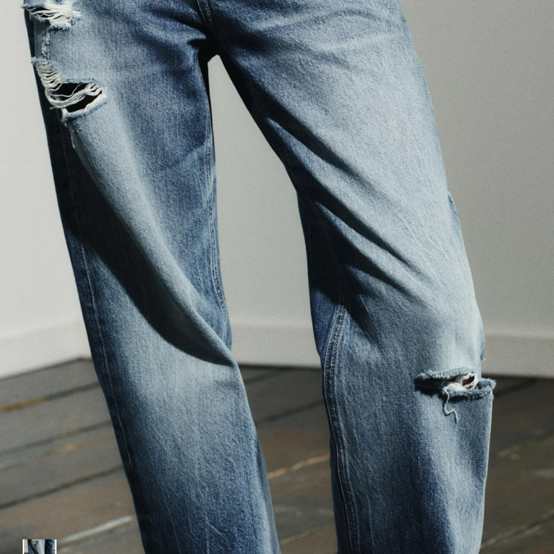 Blå slitna jeans med raka ben