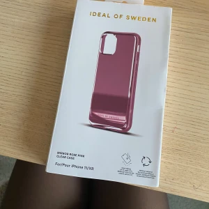 Mirror Rose Pink Clear Case för iPhone 11/XR - Stilrent mobilskal i färgen Mirror Rose Pink från Ideal of Sweden, anpassat för iPhone 11/XR. Tillverkat av återvunnet material och ger extra skydd med spegelfunktion. Produkten är ny i originalförpackning utan synliga defekter.