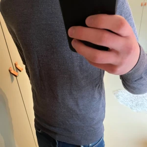 Grå stickad tröja från Uniqlo - Säljer en snygg grå stickad tröja från Uniqlo i storlek S. Tröjan har rund hals och långa ärmar, perfekt för lager-på-lager under kyliga dagar. Materialet är mjukt och skönt mot huden, och den neutrala färgen gör den enkel att matcha med allt.