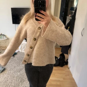 Beige stickad kofta med knappar - Säljer en supermysig beige stickad kofta med stora knappar framtill. Den finns inte längre att köpa och för mig kommer den inte till använding 💞