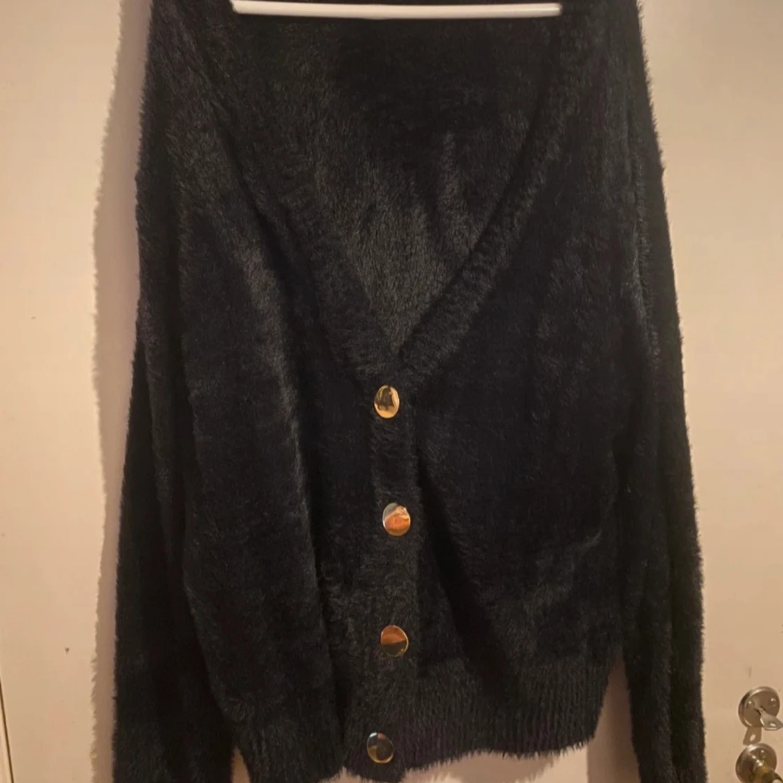 Svart fluffig kofta med guldknappar