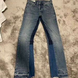 Patchade bootcut jeans från Zara - Unika blå bootcut jeans från Zara med coola patchade detaljer i olika denimnyanser längs framsidan av benen. Klassisk femficksmodell, normal passform och råa kanter vid benslut. Perfekta för dig som vill sticka ut med en trendig look.