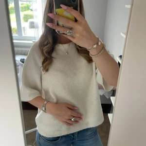 Vit stickad tröja från 157, XS - Vit stickad tröja från 157 i storlek XS. Tröjan har en avslappnad passform med halvlånga ärmar och rund halsringning. Perfekt att matcha med jeans för en enkel och stilren look.